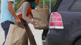 Customers packing groceries in their hatchback