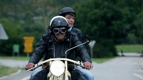 Middle aged couple on retro motorcycle