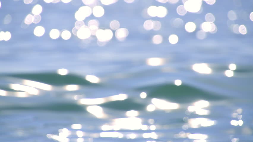 Sparkling fresh wavy water is shining on a sunny summer day in slow motion,