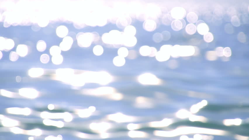 Sparkling fresh wavy water is shining on a sunny summer day in slow motion,