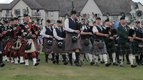 NAIRN, SCOTLAND - AUGUST 17: Massed pipe bands marching at the Highland Games in Nairn, Scotland on August 17, 2013. Highland games events are a popular tourist attraction during the Scottish summer.