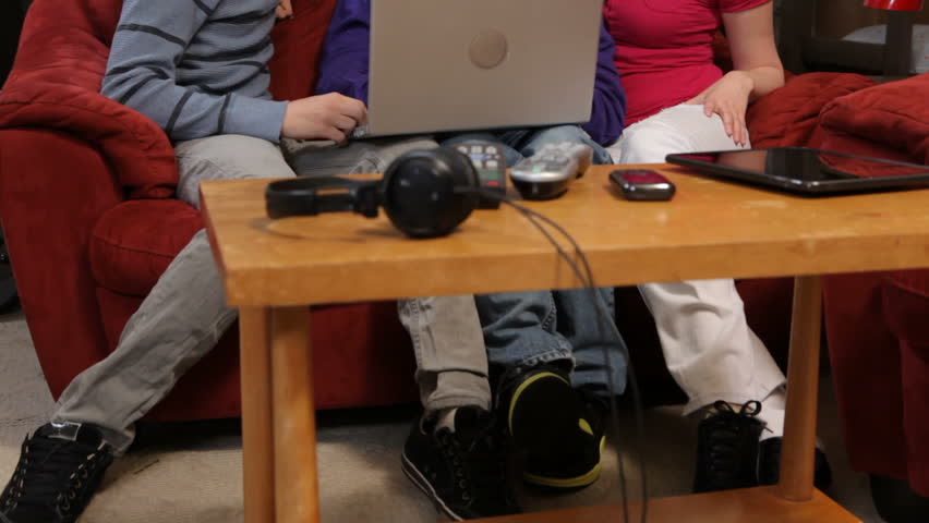Group of young people look at laptop computer together