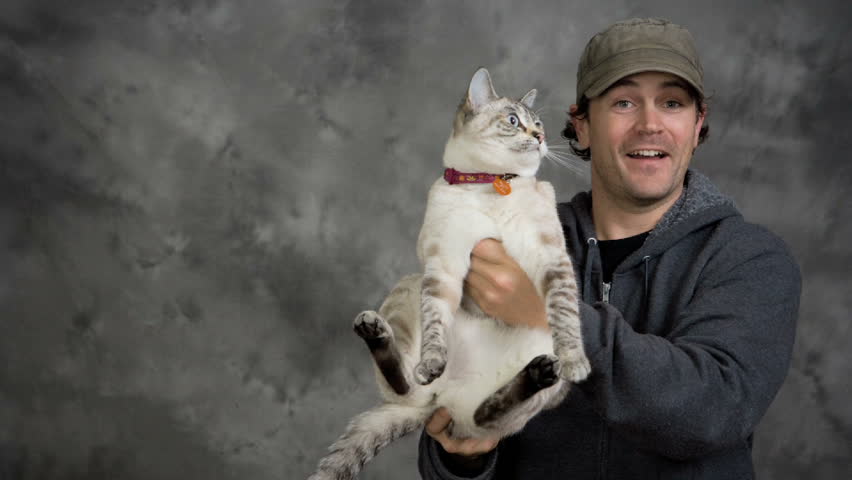 Man and woman couple pose for photo shoot with their two cats.