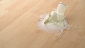 Dropping glass of milk and breaking on wooden floor shooting with high speed camera, phantom flex. - Powered by Shutterstock - Get 15% off with code: PIKWIZARD15