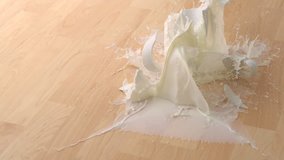 Dropping cup of milk and breaking on wooden floor shooting with high speed camera, phantom flex. - Powered by Shutterstock - Get 15% off with code: PIKWIZARD15