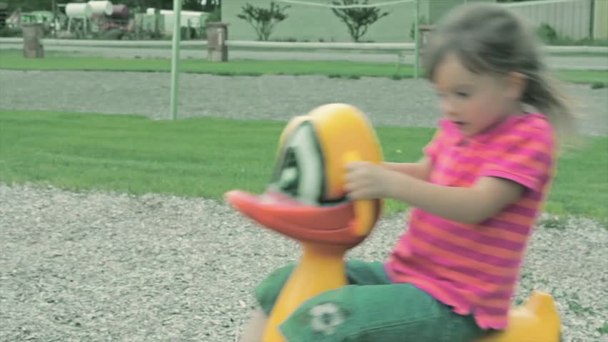 A cute little girl plays at the park