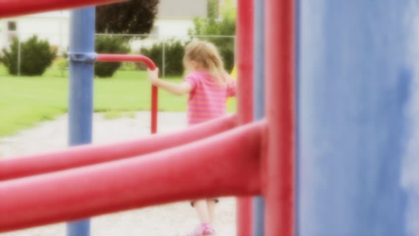 A little girl playing on toys at the park