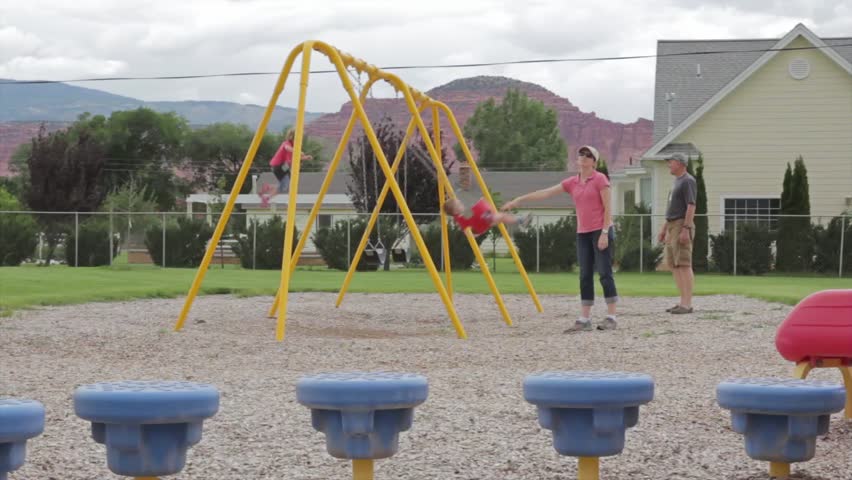 Family playing on swings at the park
