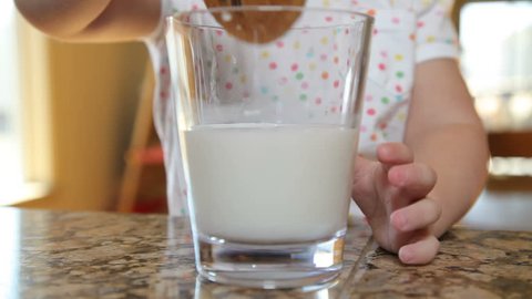Closeup of young girl dipping cookies in milk
