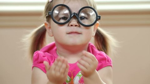 Young girl playing with silly glasses
