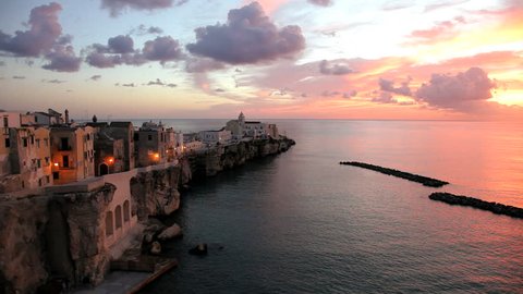 View of the beautiful scenic town of Vieste town jutting out in to the Adriatic Sea on a rocky promontory at sunrise in Puglia, Italy