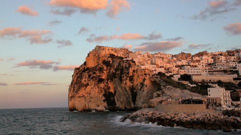 Scenic view of Adriatic tide breaking against the sea wall of the historic town Peschici on a rocky cliff in the National Park of Gargano, Promontorio Del Gargano, Puglia, Italy