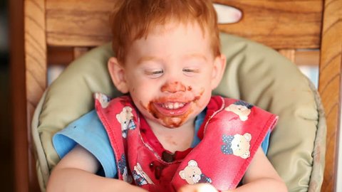 Baby getting messy eating chocolate pudding in HD