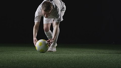 A soccer player sets up a penalty kick and then kicks the ball. Medium slow motion shot. Stock Video