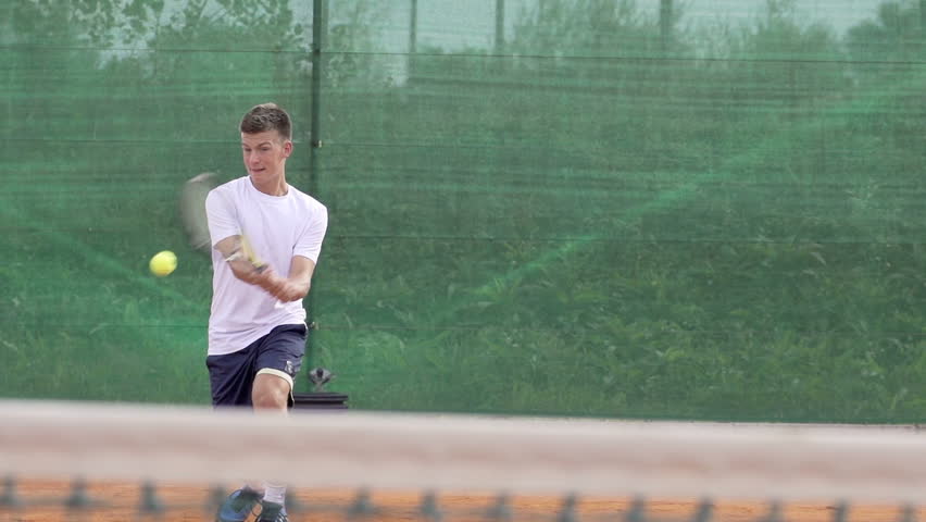 Slow Motion Shot Of A Young Professional Tennis Player Hitting The Tennis Ball