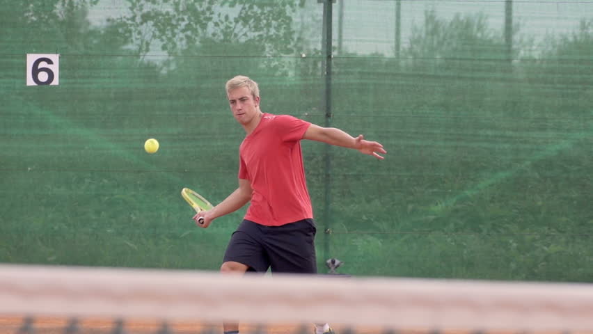 Slow Motion Shot Of Athletic Tennis Player Hitting Tennis Ball With Tennis
