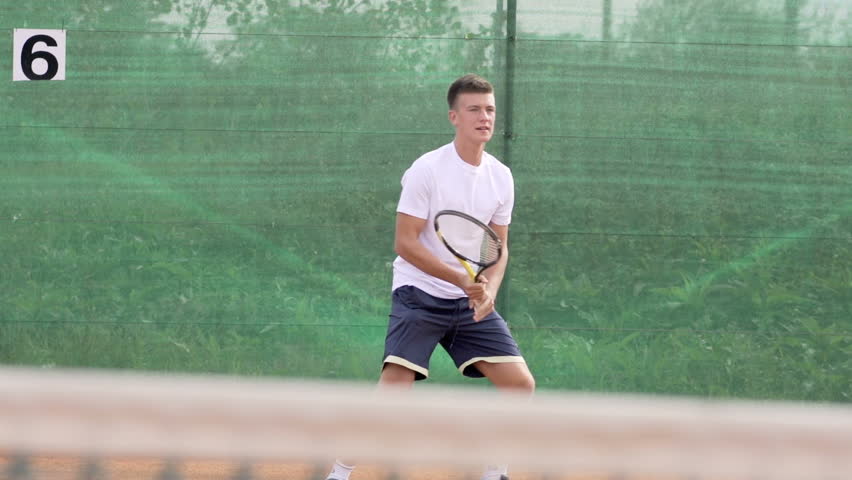 Slow Motion Shot Of A Young Left-Handed Tennis Player Training Tennis On Clay