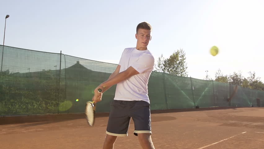 Slow Motion Shot Of A Young Professional Tennis Player Hitting Tennis Ball With