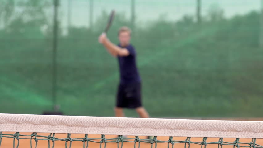 Slow Motion Dolly Shot Of A Professional Tennis Player Playing Tennis. Focus On
