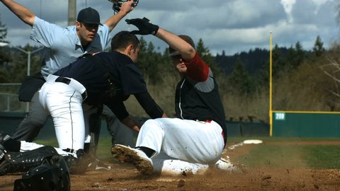Baseball player slides is safe at home plate, slow motion