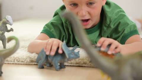Young boy playing with dinosaurs 
