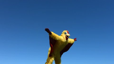 Person in chicken costume jumps in the air, slow motion