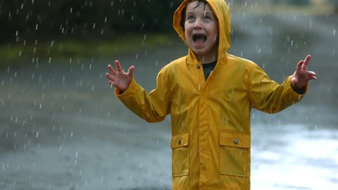 Young boy playing in rain, slow motion