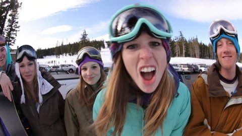 Group of snowboarders make faces, fisheye shot