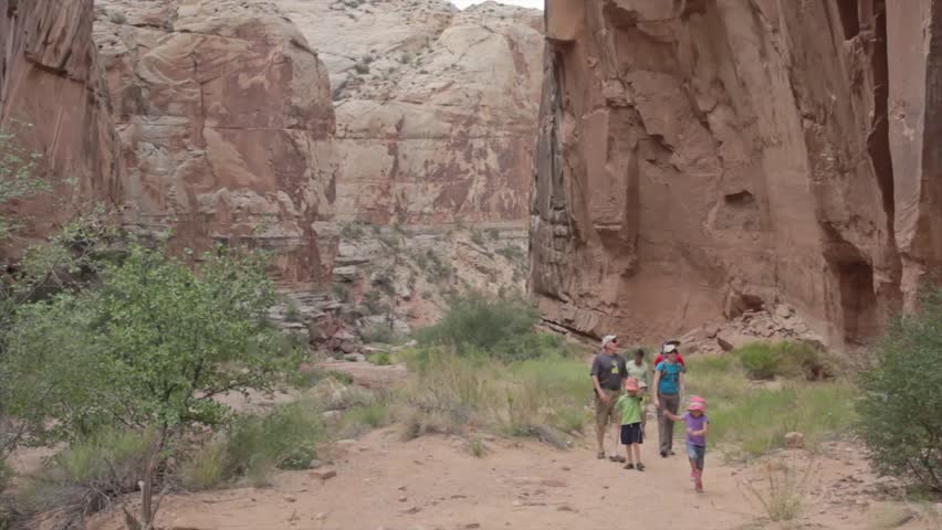 A family walking through a deep slot canyon