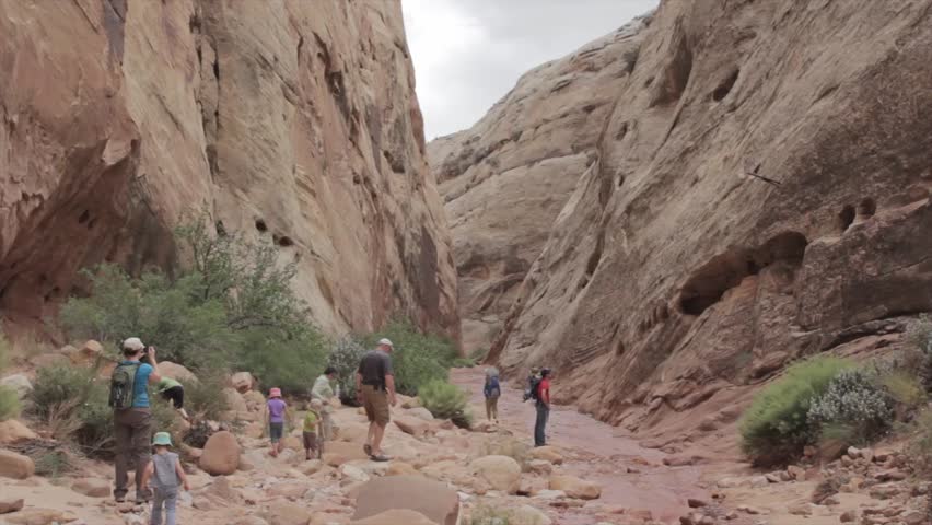 Tourists walking through a deep slot canyon in Capitol Reef National Park