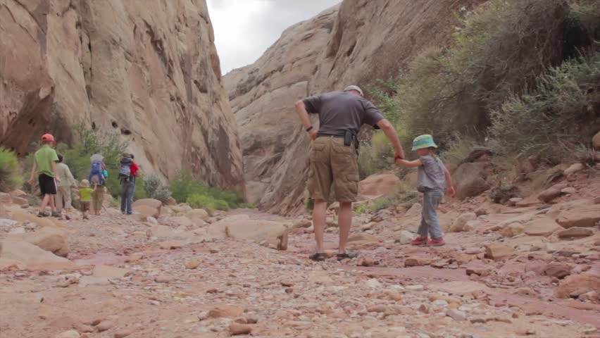 A family walking in a desert canyon in Capitol Reef National Park in Southern