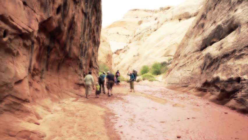 Hikers in a deep desert slot canyon