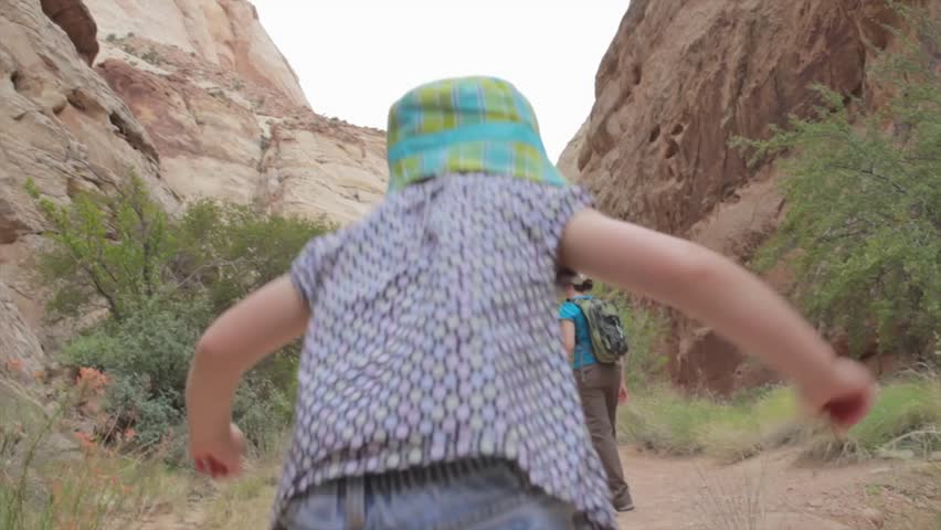 A family walking through a desert slot canyon in Capitol Reef National Park