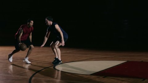 A basketball player dribbles past a defender and then shoots the ball