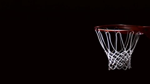 Close up of a basketball going through the net for a field goal.