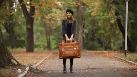 Redhead girl with suitcase outdoor