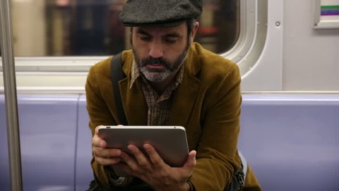 Man uses digital tablet on subway