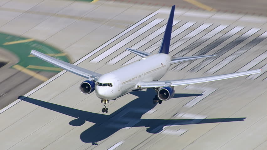 Aerial shot of passenger jet landing on runway
