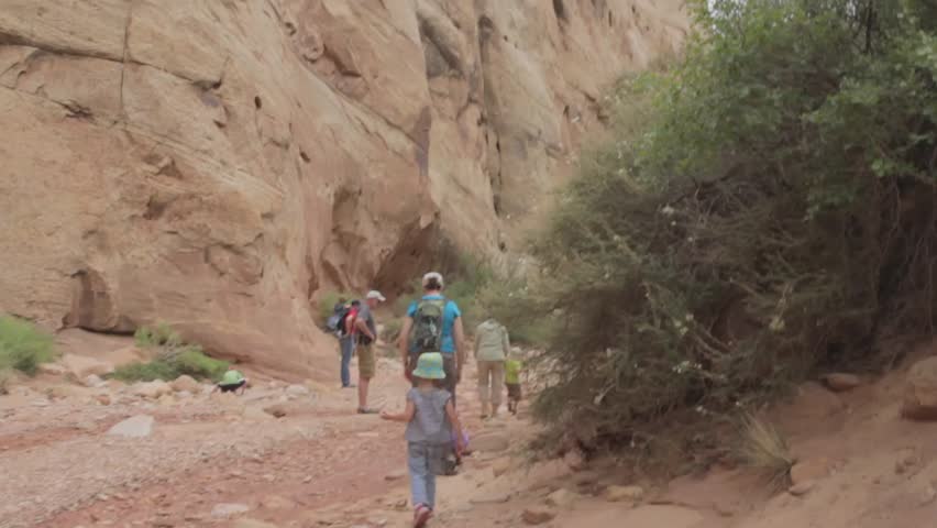 A family hiking in a cool desert slot canyon