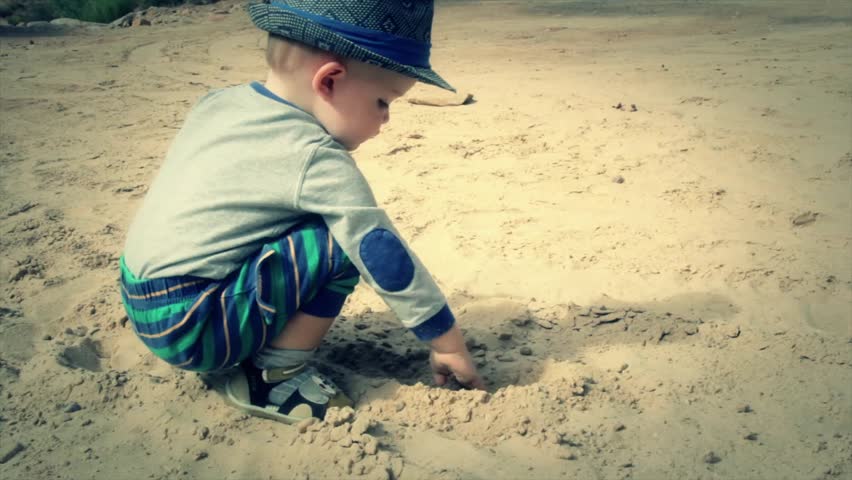 A toddler playing in the desert sand