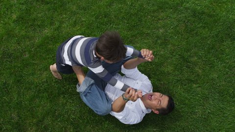 Father and son playing together in grass Arkivvideo
