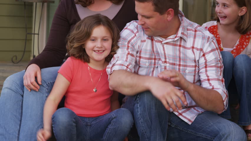 Portrait of family sitting on porch