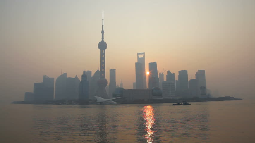 China - January 2012: Panorama view of sunrise behind modern Shanghai skyline with Oriental Pearl Tower, Huangpu River, Pudong district, Shanghai, China in January, 2012