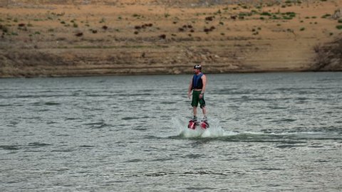 Walk on water Porpoise diving Fly Board summer fun. Son summer fun. Flyboard aerial machine for a personal watercraft allows propulsion underwater and in the air allowing person to fly like Iron Man.