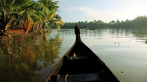 Local canoes passing on the Kerala river backwater naear Alleppey, India
