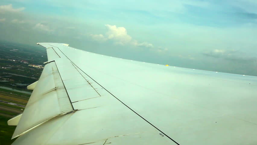WINDOW VIEW OF WING PLANE OVER GROUND