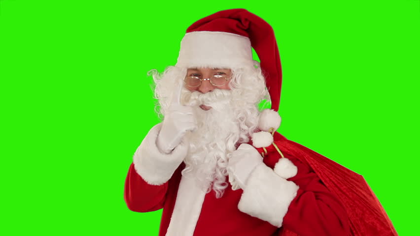 Santa Claus carrying his bag, looks at the camera sends a kiss and wave, Green