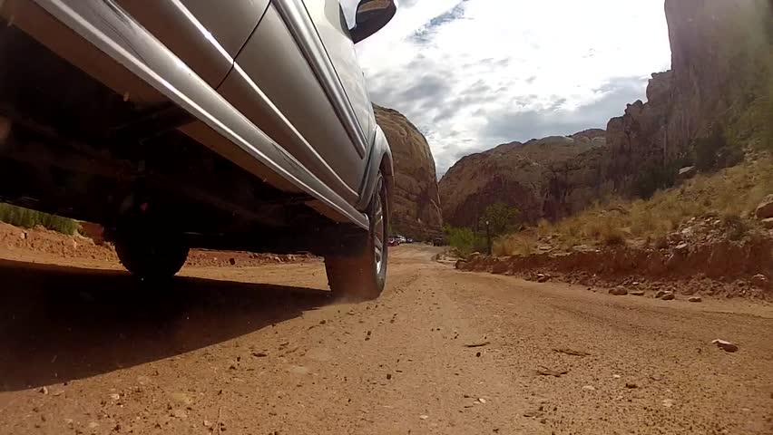 A car driving through a desert in Capitol Reef National Park in Southern Utah