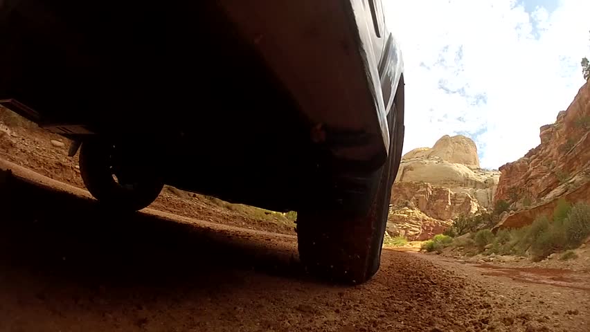 A car driving through a desert in Capitol Reef National Park in Southern Utah