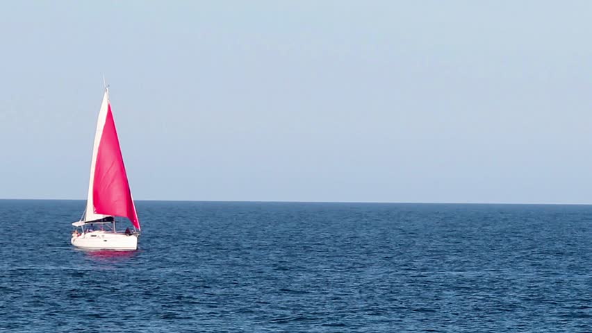 Yacht with a red sail on the sea